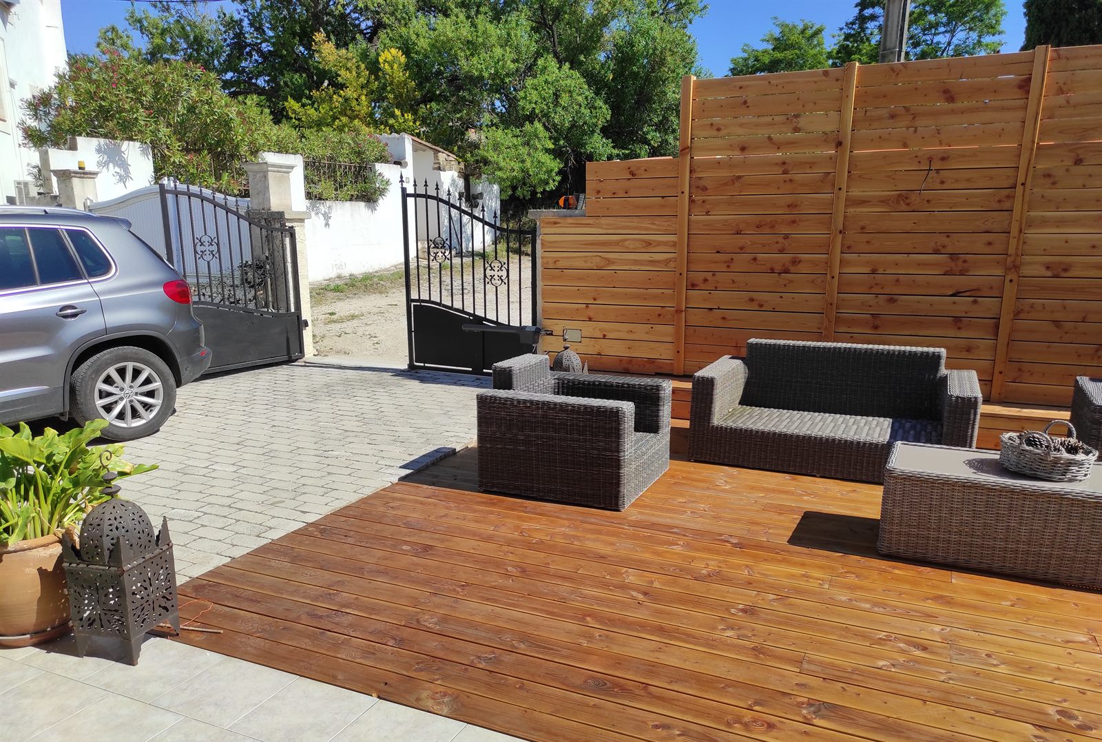 Raccord de la terrasse bois avec la cour pavée et l'entrée