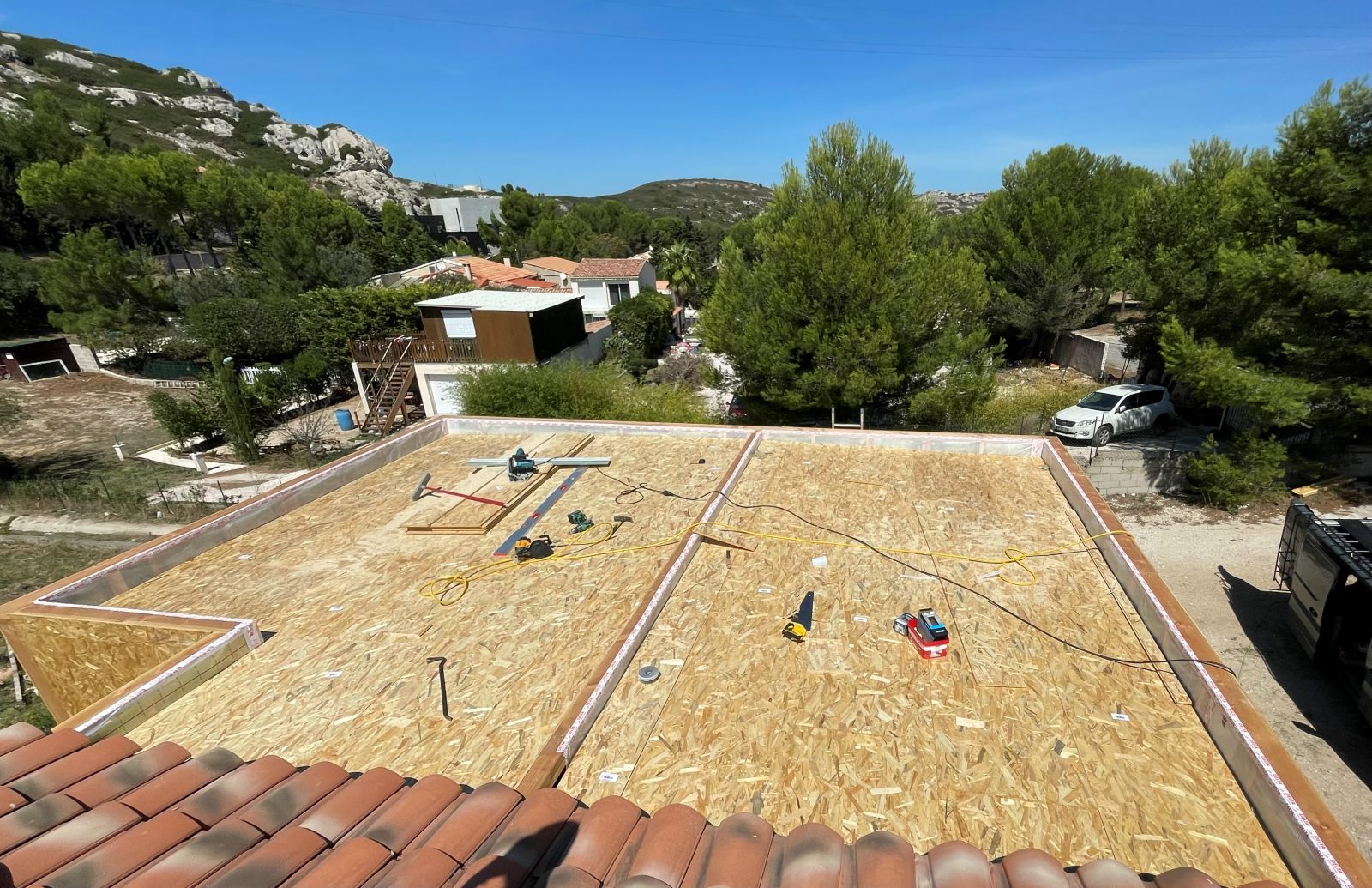 Étape chantier : plancher de toiture posé, vue dégagée sur le village